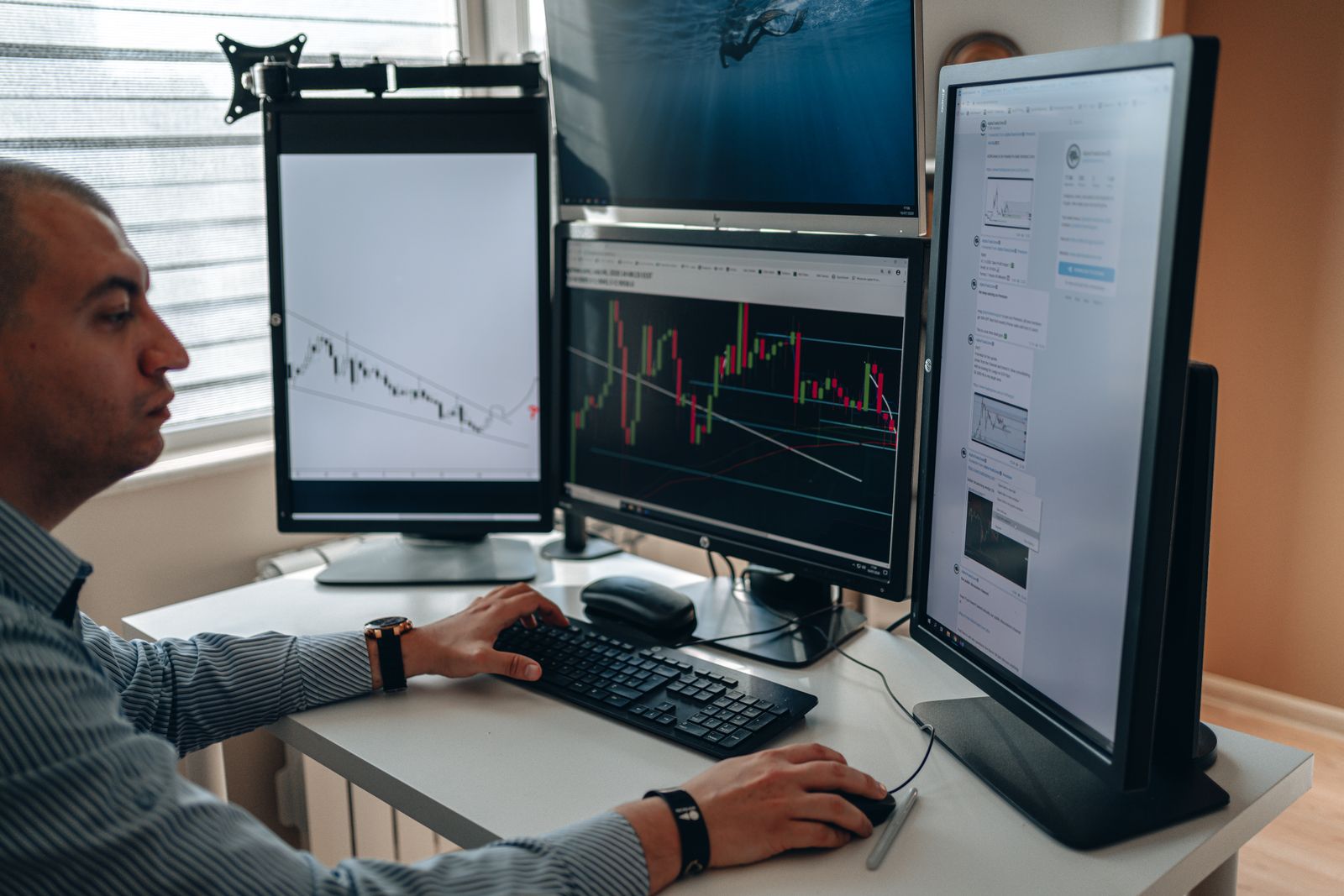 A trader working across a multi-monitor trading desk