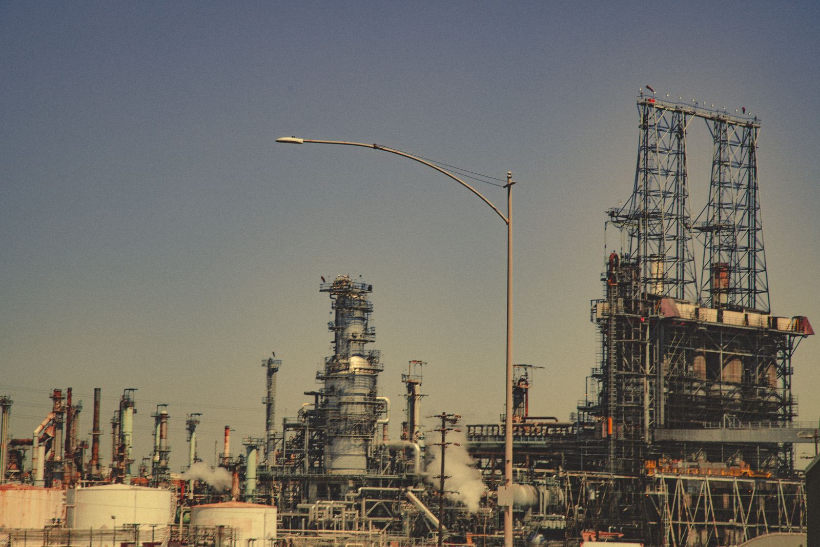 An industrial oil refinery against a clear blue sky