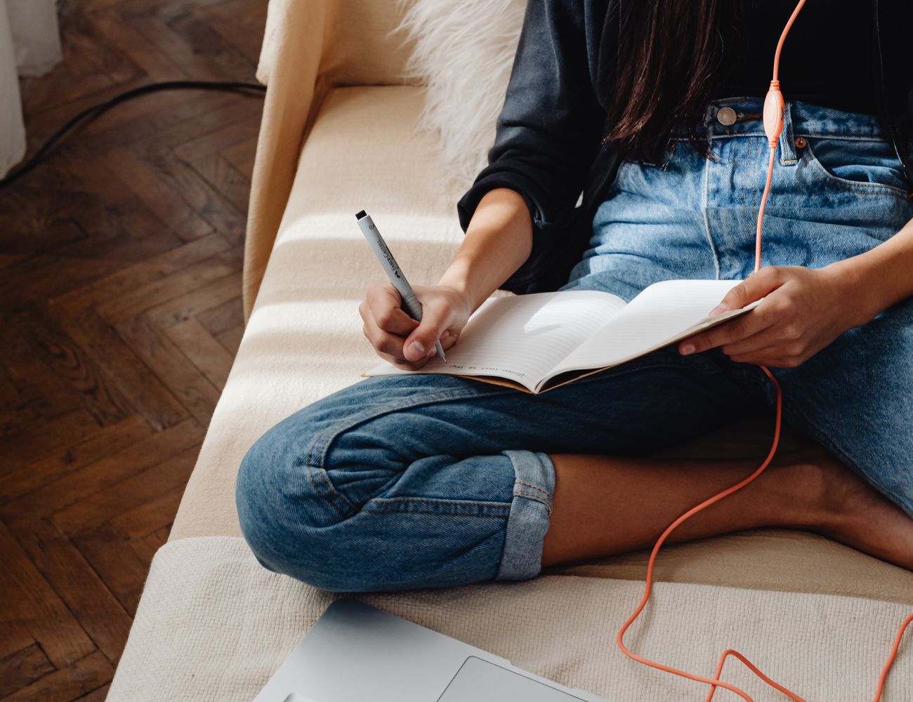 A person studying online with a laptop and notes